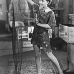 Betty Bronson as Peter Pan holding his shadow, from the 1924 silent film Peter Pan.