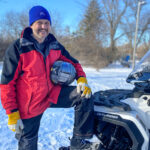 Volunteer Peter Nor with the snowmobile he uses to help maintain the Rideau Winter Trail (Martha Jeacle/The BUZZ)