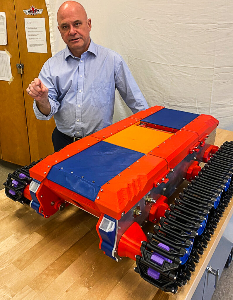 Carleton University professor Shawn Kenny with the reduced-scale model of his snow-bot. It’s part of a possible solution for earlier ice building on the Rideau Canal skateway, thus keeping it open in warmer winter temperatures. (Jack Hanna/The BUZZ)