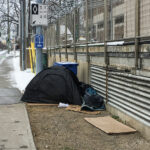 The person sleeping in this tent, beside a sidewalk on a main street in Centretown, could avoid freezing in January because of the warm air from the nearby heating vent. (Alayne McGregor/The BUZZ)