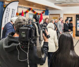 Minister Mark Holland (in grey) and MP Yasir Naqvi (to his right) tour through the Centretown Community Health Centre before making the Pharmacare announcement. (CCHC)