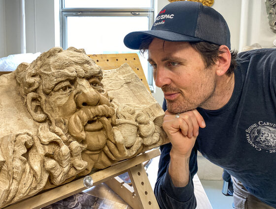Sculptor Nicholas Thompson and a plaster cast of a Parliament Hill “grotesque” he is recreating. The original was weathered, so he’s making a restored copy of it, in stone, that will be swapped in for the original. (Jack Hanna/The BUZZ)